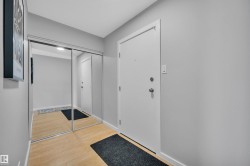 Corridor with light wood-style floors, a baseboard radiator, and a textured ceiling - 