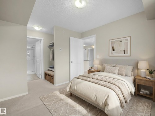 Bedroom with light carpet and a textured ceiling - 422 5816 Mullen Place, Edmonton, AB - Indoor Photo Showing Bedroom