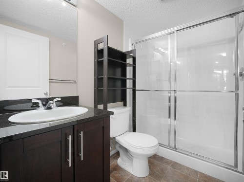 Bathroom with vanity, a textured ceiling, and a shower stall - 422 5816 Mullen Place, Edmonton, AB - Indoor Photo Showing Bathroom