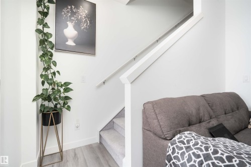 Staircase featuring wood finished floors and baseboards - 24 2072 Wonnacott Way, Edmonton, AB - Indoor Photo Showing Other Room