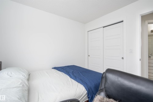 Bedroom with a textured ceiling and a closet - 24 2072 Wonnacott Way, Edmonton, AB - Indoor Photo Showing Bedroom