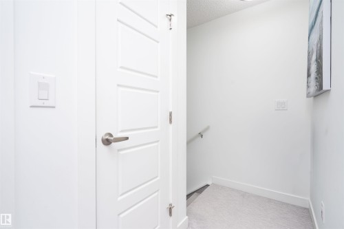 Stairs featuring a textured ceiling and baseboards - 24 2072 Wonnacott Way, Edmonton, AB - Indoor Photo Showing Other Room