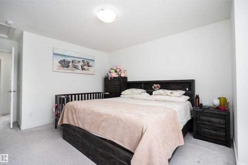 Bedroom featuring light carpet and a textured ceiling - 24 2072 Wonnacott Way, Edmonton, AB - Indoor Photo Showing Bedroom