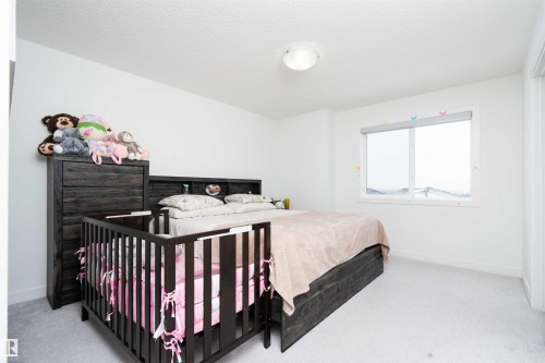 Bedroom with a textured ceiling and carpet floors - 24 2072 Wonnacott Way, Edmonton, AB - Indoor Photo Showing Bedroom