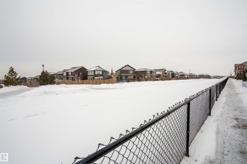 Yard layered in snow with a residential view - 24 2072 Wonnacott Way, Edmonton, AB - Outdoor