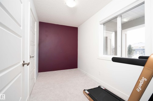 Workout area with light colored carpet and a textured ceiling - 24 2072 Wonnacott Way, Edmonton, AB - Indoor Photo Showing Other Room