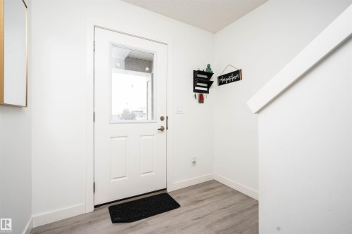Doorway with wood finished floors and a textured ceiling - 24 2072 Wonnacott Way, Edmonton, AB - Indoor Photo Showing Other Room