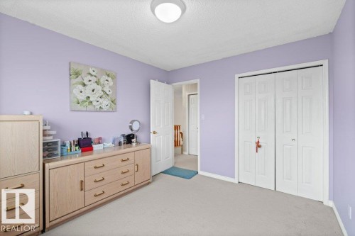 Bedroom with light carpet, a textured ceiling, and a closet - 11608 11A Avenue, Edmonton, AB - Indoor Photo Showing Bedroom
