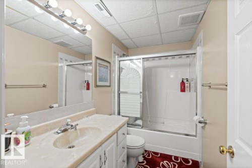 Full bathroom with bath / shower combo with glass door, vanity, and a drop ceiling - 11608 11A Avenue, Edmonton, AB - Indoor Photo Showing Bathroom