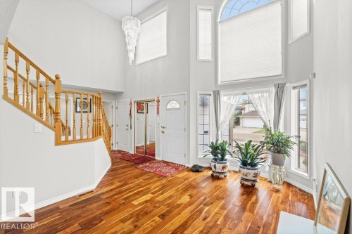 Entrance foyer with a high ceiling, stairway, wood finished floors, and a chandelier - 11608 11A Avenue, Edmonton, AB - Indoor Photo Showing Other Room
