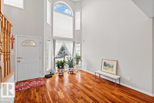 Entrance foyer featuring healthy amount of natural light, a towering ceiling, and wood finished floors - 11608 11A Avenue, Edmonton, AB - Indoor Photo Showing Other Room With Fireplace