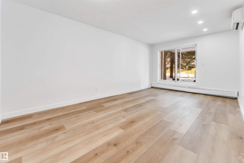 Spare room featuring a baseboard heating unit, light wood-style flooring, and recessed lighting - 107 9760 176 St, Edmonton, AB - Indoor