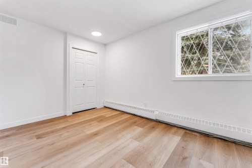 Unfurnished room with baseboard heating and light wood-type flooring - 107 9760 176 St, Edmonton, AB - Indoor Photo Showing Other Room