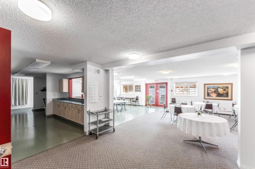 Rec room featuring a textured ceiling and french doors - 107 9760 176 St, Edmonton, AB - Indoor