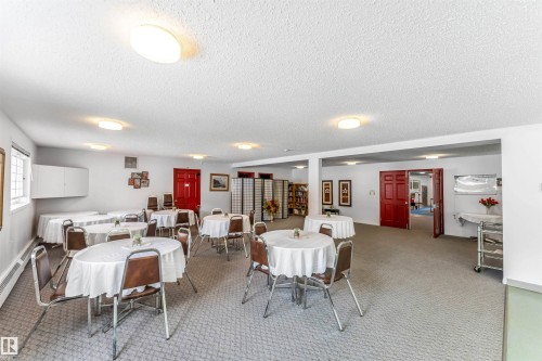 Dining room featuring light carpet, a textured ceiling, and a baseboard radiator - 107 9760 176 St, Edmonton, AB - Indoor Photo Showing Dining Room