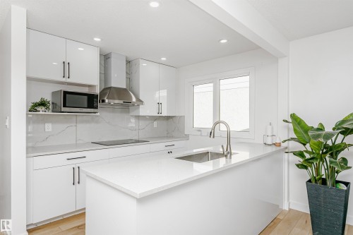 Kitchen featuring white cabinetry, tasteful backsplash, a peninsula, modern cabinets, and recessed lighting - 13520 113A Street, Edmonton, AB - Indoor Photo Showing Kitchen With Upgraded Kitchen