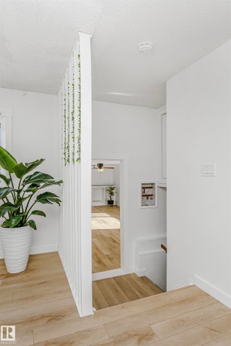 Hall with light wood-style flooring, an upstairs landing, and a textured ceiling - 13520 113A Street, Edmonton, AB - Indoor Photo Showing Other Room