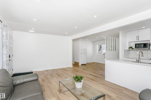 Living area featuring light wood-style flooring, recessed lighting, and a textured ceiling - 13520 113A Street, Edmonton, AB - Indoor