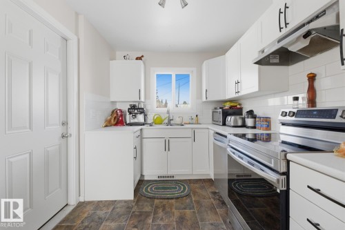 Kitchen featuring stainless steel appliances, light countertops, and white cabinetry - 11332 134 Avenue, Edmonton, AB - Indoor Photo Showing Kitchen