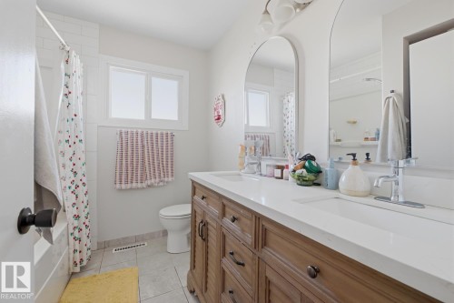 Full bath with double vanity and light tile patterned floors - 11332 134 Avenue, Edmonton, AB - Indoor Photo Showing Bathroom