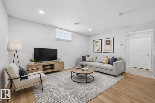 Living room featuring light-colored flooring, recessed lighting, and a white entry door - 11332 134 Avenue, Edmonton, AB - Indoor Photo Showing Living Room