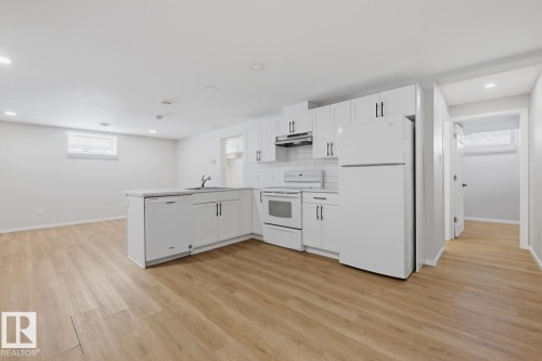 Kitchen with white cabinetry, a refrigerator, stove, dishwasher, and sink - 11332 134 Avenue, Edmonton, AB - Indoor Photo Showing Kitchen