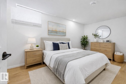 This bedroom features light wood flooring, a window with blinds, and white walls - 11332 134 Avenue, Edmonton, AB - Indoor Photo Showing Bedroom