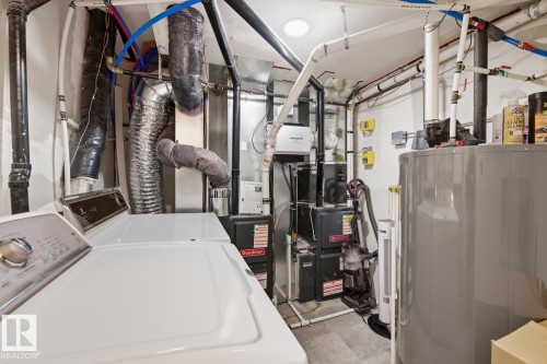 Utility area featuring laundry appliances, a water heater, and mechanical systems - 11332 134 Avenue, Edmonton, AB - Indoor Photo Showing Laundry Room