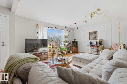 Living area with wood finished floors and a decorative wall - 11332 134 Avenue, Edmonton, AB - Indoor Photo Showing Living Room