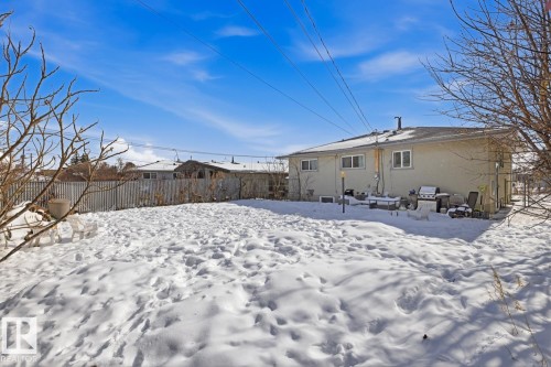 The property features a spacious backyard with a fence and a rear exterior wall with multiple windows - 11332 134 Avenue, Edmonton, AB - Outdoor