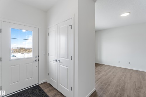 Doorway with wood finished floors and baseboards - 2467 Alces Link Link, Edmonton, AB - Indoor Photo Showing Other Room
