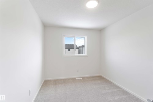 Spare room featuring light carpet and baseboards - 2467 Alces Link Link, Edmonton, AB - Indoor Photo Showing Other Room