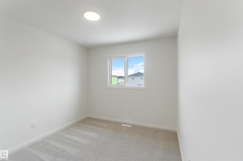 Unfurnished room with light carpet and baseboards - 2467 Alces Link Link, Edmonton, AB - Indoor Photo Showing Other Room