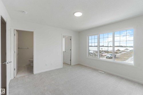 Unfurnished bedroom featuring light carpet and connected bathroom - 2467 Alces Link Link, Edmonton, AB - Indoor Photo Showing Other Room