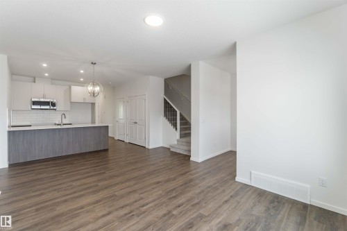 Kitchen featuring white cabinets, hanging lights, open floor plan, and light countertops - 2467 Alces Link Link, Edmonton, AB - Indoor Photo Showing Kitchen