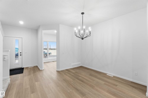 Foyer featuring hanging lights and light wood-style floors - 8652 Edgemont Link Link, Edmonton, AB - Indoor Photo Showing Other Room