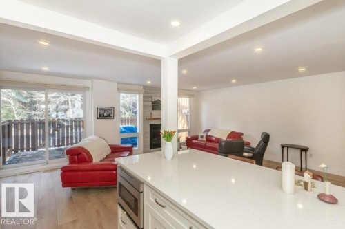 Kitchen with open floor plan and extensive quartz counters - 88 Hearthstone Nw, Edmonton, AB - Indoor Photo Showing Other Room With Fireplace