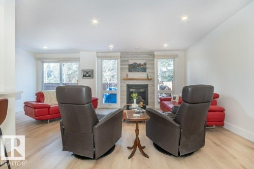Living area with gas fireplace and and windows facing West - 88 Hearthstone Nw, Edmonton, AB - Indoor Photo Showing Living Room With Fireplace