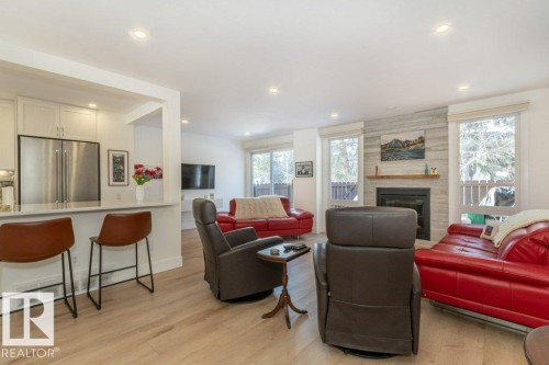 open to the impressive kitchen - 88 Hearthstone Nw, Edmonton, AB - Indoor Photo Showing Living Room With Fireplace