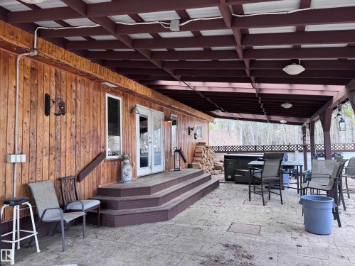 Covered outdoor patio area featuring a stamped concrete floor - 59415A Rg Rd 240, Rural Westlock County, AB -  With Deck Patio Veranda With Exterior