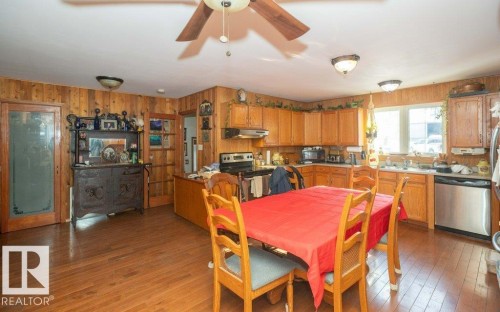 Dining space featuring dark wood finished floors, a ceiling fan, and wood walls - 59415A Rg Rd 240, Rural Westlock County, AB - Indoor Photo Showing Kitchen