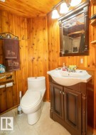 Bathroom featuring a shower with curtain, vanity, wood ceiling, and wooden walls - 