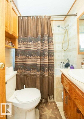 Bathroom featuring vanity, shower / bath combination with curtain, and light tile patterned floors - 59415A Rg Rd 240, Rural Westlock County, AB - Indoor Photo Showing Bathroom