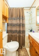 Bathroom featuring vanity, shower / bath combination with curtain, and light tile patterned floors - 