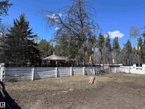 Expansive outdoor area featuring a white horizontal plank fence with a dark lattice top - 59415A Rg Rd 240, Rural Westlock County, AB - Outdoor