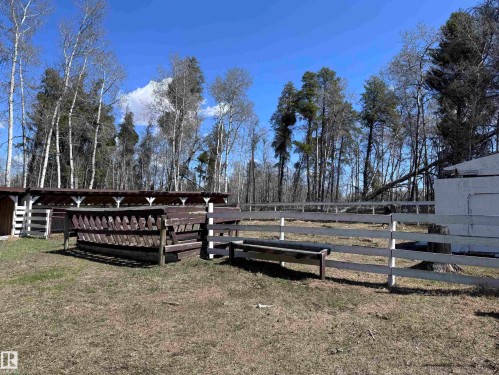 Pasture area featuring perimeter fencing, a covered feeding structure, and a secondary white painted fence - 59415A Rg Rd 240, Rural Westlock County, AB - Outdoor