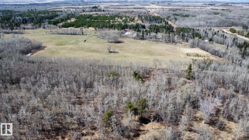 Expansive rural landscape featuring a mix of mature deciduous and evergreen trees, open fields, and distant agricultural areas - 59415A Rg Rd 240, Rural Westlock County, AB - Outdoor With View