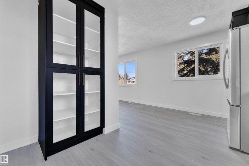 Unfurnished room featuring a textured ceiling and light wood-style flooring - 8635 33 Avenue, Edmonton, AB - Indoor Photo Showing Other Room