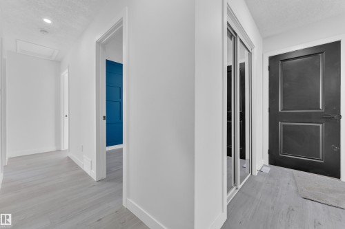Hallway featuring light wood-type flooring, a textured ceiling, and recessed lighting - 8635 33 Avenue, Edmonton, AB - Indoor Photo Showing Other Room