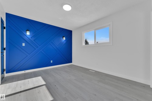 Unfurnished room featuring a decorative wall and light wood-style flooring - 8635 33 Avenue, Edmonton, AB - Indoor Photo Showing Other Room